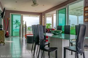 a dining room with a glass table and chairs at KATA PENTHOUSE SEA VIEW private POOL in Kata Beach