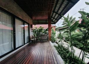 un porche de una casa con terraza de madera en Tropicana Lanta Resort, en Ko Lanta