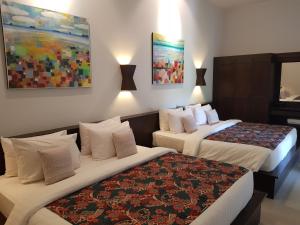 una habitación de hotel con 2 camas y un cuadro en la pared en Tropicana Lanta Resort, en Ko Lanta