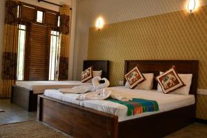 sypialnia z 2 łóżkami i ręcznikami w obiekcie Buddika Safari & Resort w mieście Udawalawe