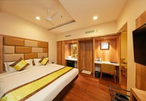 a bedroom with a bed and a desk in a room at Taz Kamar Family Hotel in Chennai