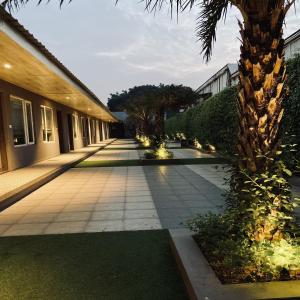 a walkway with palm trees and a building at Kingston Resort in Kānpur