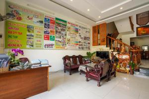 a waiting room with chairs and posters on the wall at Windy River Homestay in Hoi An