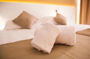 a white bed with pillows on top of it at Planet Hotels BLUE - Adults Only 16 years in El Arenal
