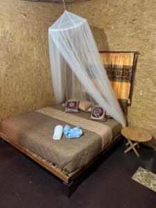 a bedroom with a bed with a mosquito net at Easylife Bungalow in Ko Lanta