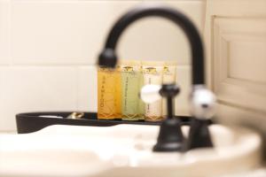 a bathroom sink with a faucet with two cups at Kaesler Cottages in Nuriootpa