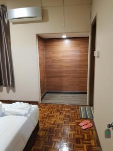 a bedroom with a closet with a wooden door at Sandra Homestay in Tawau