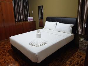 a bedroom with a bed with a dress on it at Sandra Homestay in Tawau