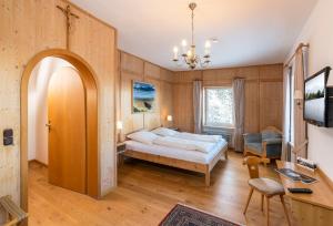 a bedroom with a bed and a desk and a chair at Klostergasthof Maria Eck in Siegsdorf