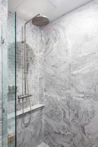 La salle de bains est pourvue d'une douche avec une porte en verre. dans l'établissement Sook Hotel, à Ranong