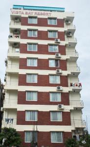 un edificio de apartamentos alto con gente en los balcones en Hotel Vista Bay, en Cox's Bazar