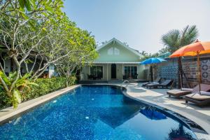 einen Pool mit 2 Stühlen und einem Sonnenschirm in der Unterkunft Kata Tranquil Villa - SHA Plus in Karon Beach