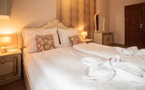 - une chambre avec 2 lits dotés de draps et d'oreillers blancs dans l'établissement My-Lord LuxApartman, à Eger