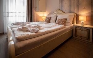 un grande letto con lenzuola bianche e archi di My-Lord LuxApartman a Eger