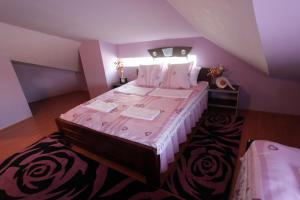 una camera con un grande letto in una camera viola di Villa Atina a Stara Pazova