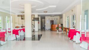 une salle à manger avec des tables rouges et des chaises blanches dans l'établissement Sun & Sea Hotel, à Duong Dong