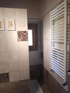 a bathroom with a shower with a window and a tub at La Zamarriega in Segovia