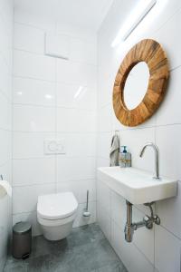 ein weißes Bad mit einem WC und einem Spiegel in der Unterkunft Landhaus Bergpanorama TOP 7 in Damüls