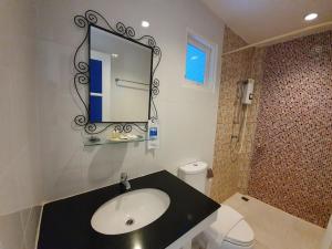 ein Badezimmer mit einem Waschbecken, einem Spiegel und einem WC in der Unterkunft Baan Kung Kang De Pai in Pai