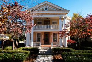 Casa blanca con porche y árboles en Showers Inn, en Bloomington