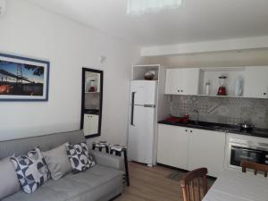 uma sala de estar com um sofá e uma cozinha em Ap pe na areia em ingleses - Florianópolis SC em Florianópolis