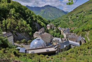a group of buildings in a valley with mountains at MAISON BELLEVUE 3 étoiles 4 à 10P in Laruns