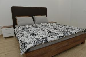 łóżko z czarno-białą kołdrą w obiekcie Apartman Jankulovski w mieście Kraljevo