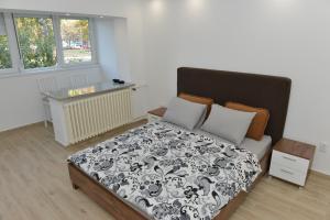 sypialnia z łóżkiem z czarno-białą kołdrą w obiekcie Apartman Jankulovski w mieście Kraljevo