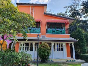 an orange house with a balcony on top of it at Baan Kung Kang De Pai in Pai