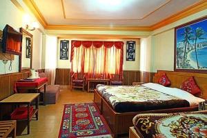a bedroom with two beds and a table and a desk at hotel Seven Seventeen in Darjeeling