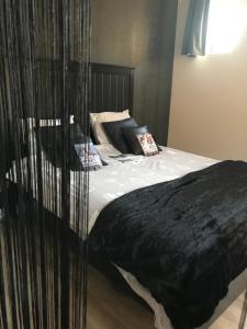 un letto con piumone nero in una camera da letto di Gastenverblyf Heerlyck Huys a Lommel