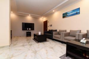 Durra Taraf 1 Residential في الدمام: غرفة معيشة مع كنب وتلفزيون بشاشة مسطحة