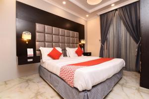 une chambre d'hôtel avec un grand lit avec des oreillers rouges dans l'établissement درة ترف 1 لشقق المفروشة المخدمة Durra Taraf 1 Residential, à Dammam 24 autres photos