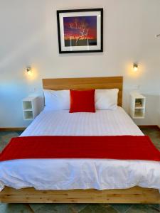a bedroom with a large bed with a red pillow at Cloudscape Apartment No 2 in Kingscote