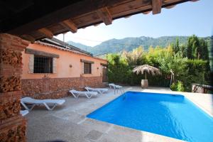 a swimming pool in front of a house at Cortijo El Lerele in Cazorla