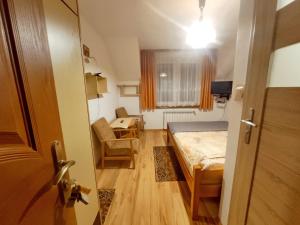 a bedroom with a bed and a desk and a window at Pokoje Panorama in Wysowa-Zdrój