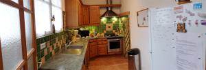- une petite cuisine avec du carrelage vert sur le mur dans l'établissement Villa Athena, à LʼÎle-Rousse