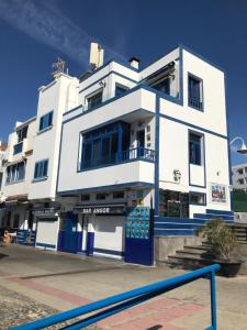 un edificio blanco con adornos azules en una calle en CasaPello TOP TERRACE, en Puerto de las Nieves