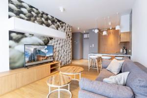 a living room with a couch and a tv at Cotton House in Łódź