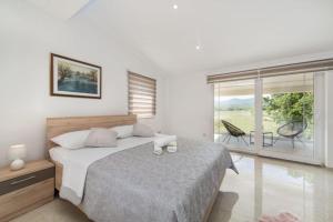 a white bedroom with a bed and a balcony at Villa Maria in Donji Proložac +40 photos