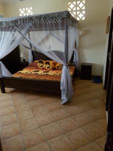 a bedroom with a bed with a canopy at Villa LeoMar Diani Beach in Diani Beach