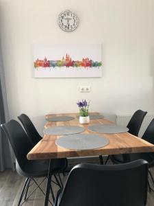 uma mesa de jantar com cadeiras e um relógio na parede em Ferienhaus Wattkieker em Sehestedt