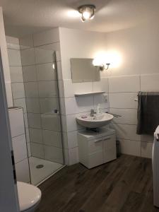 a bathroom with a sink and a toilet and a mirror at Ferienhaus Wattkieker in Sehestedt