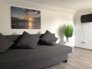 a couch in a living room with a painting on the wall at Ferienhaus Wattkieker in Sehestedt