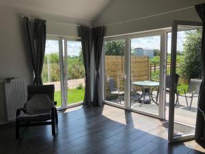 a living room with sliding glass doors and a table and chairs at Ferienhaus Wattkieker in Sehestedt