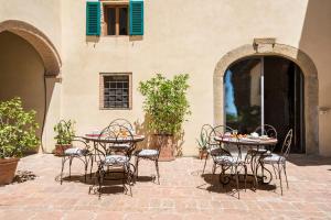 eine Terrasse mit Tischen und Stühlen in einem Gebäude in der Unterkunft Il Paluffo in Certaldo