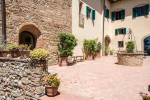 a courtyard with potted plants and a stone wall at Il Paluffo in Certaldo