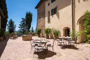 a patio with tables and chairs in a courtyard at Il Paluffo in Certaldo