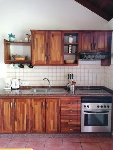 a kitchen with wooden cabinets and a stove top oven at Casa Juana in Valle Gran Rey