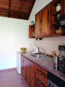 una cocina con armarios de madera y fregadero en Casa Juana, en Valle Gran Rey